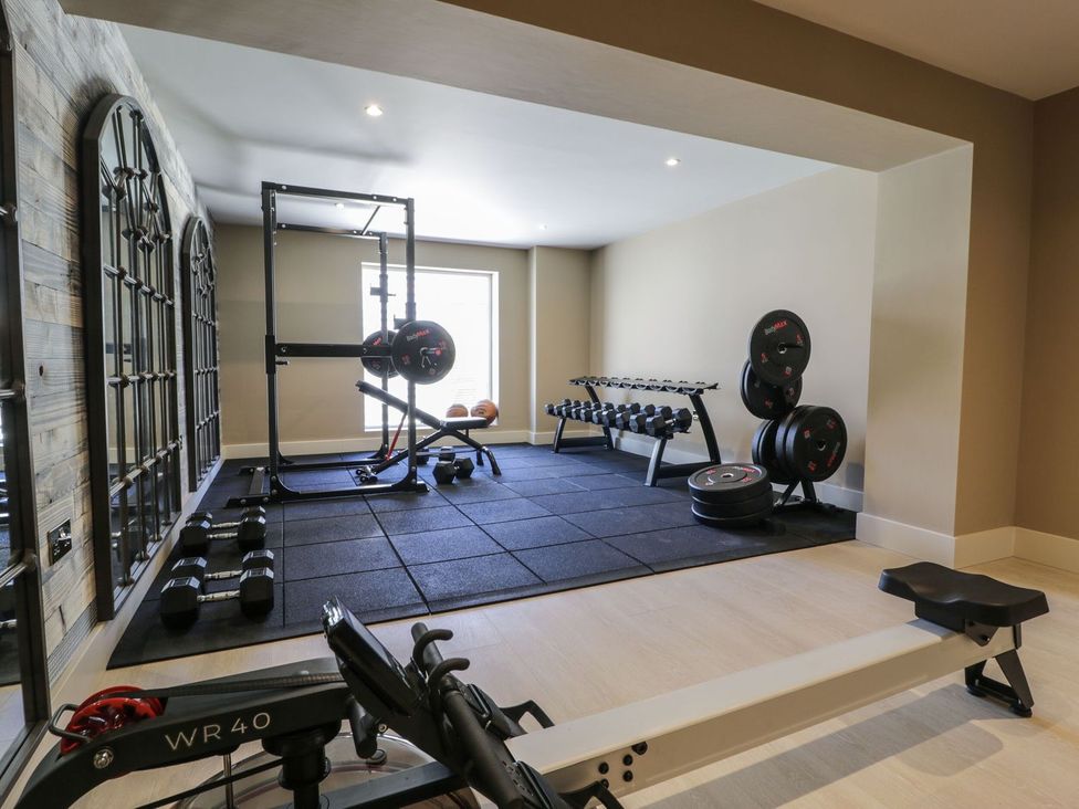 A gym with exercise equipment and weights at Bell House in Llanfechell