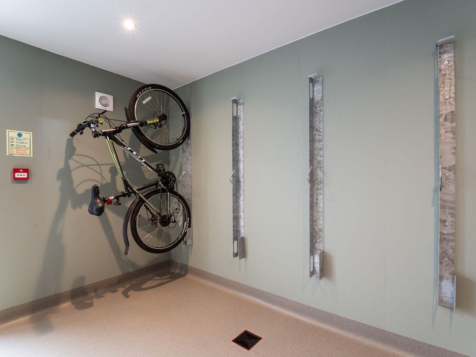 A bike storage area with a bicycle mounted on the wall at Bell House in Llanfechell