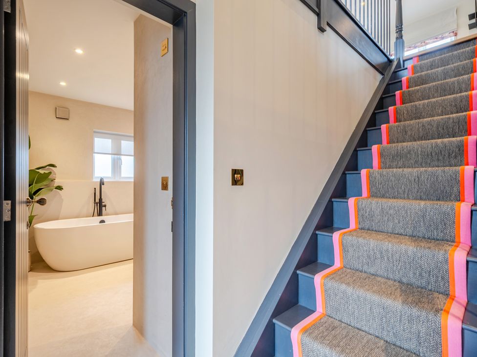 A hallway with a staircase and a bathtub visible at Bell House in Llanfechell