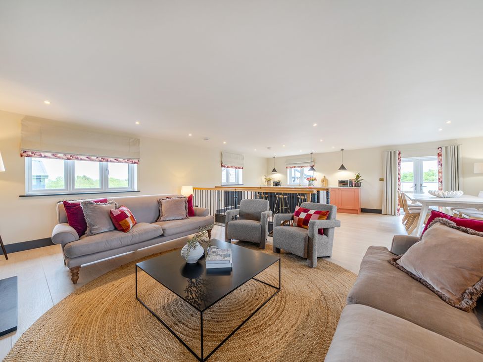 A living room with a sofa and armchairs at Bell House in Llanfechell
