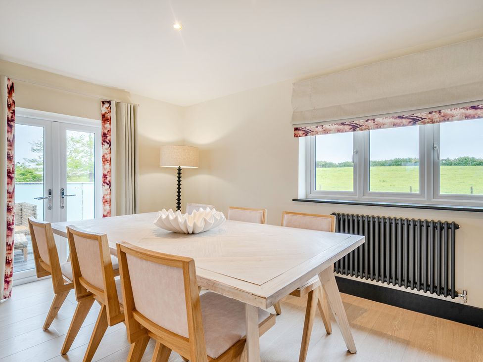 A dining room with a table and chairs at Bell House in Llanfechell