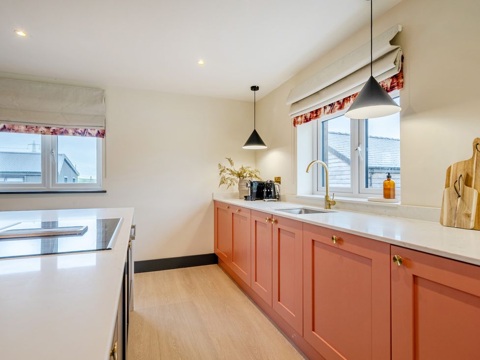 A kitchen with cabinets and appliances at Bell House in Llanfechell