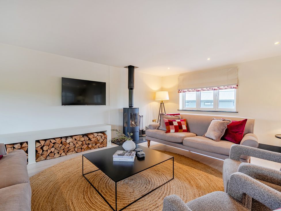 A living room with a television and fireplace at Bell House in Llanfechell