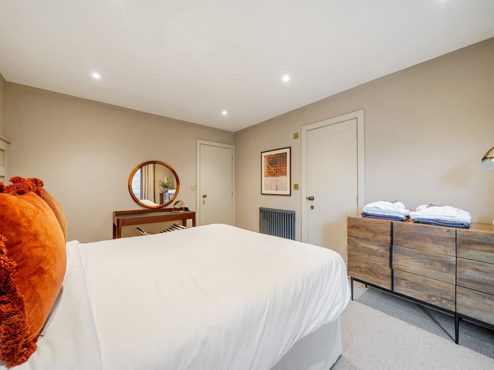A bedroom with a bed and dresser at Bell House in Llanfechell