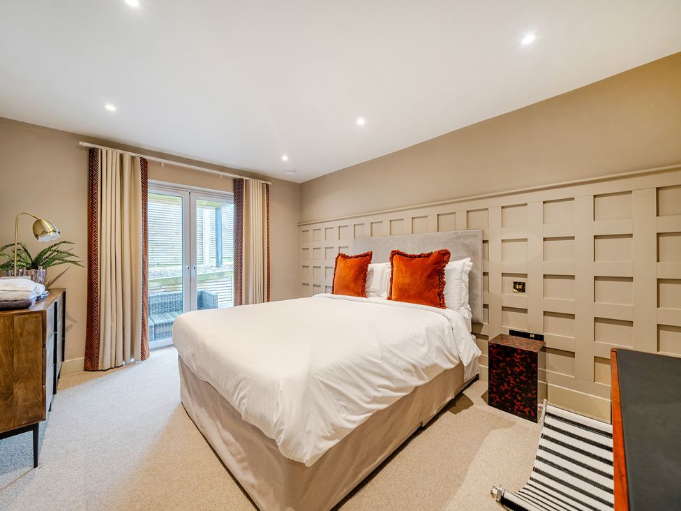 A bedroom with a bed and side table at Bell House in Llanfechell