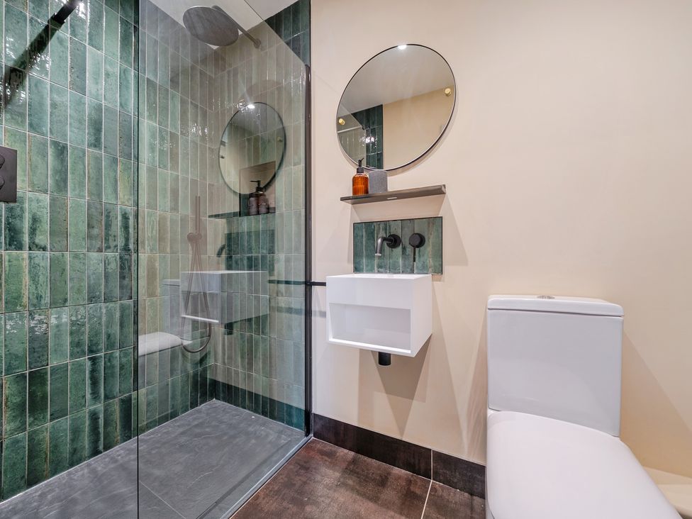 A bathroom with a shower, toilet, and sink at Bell House in Llanfechell