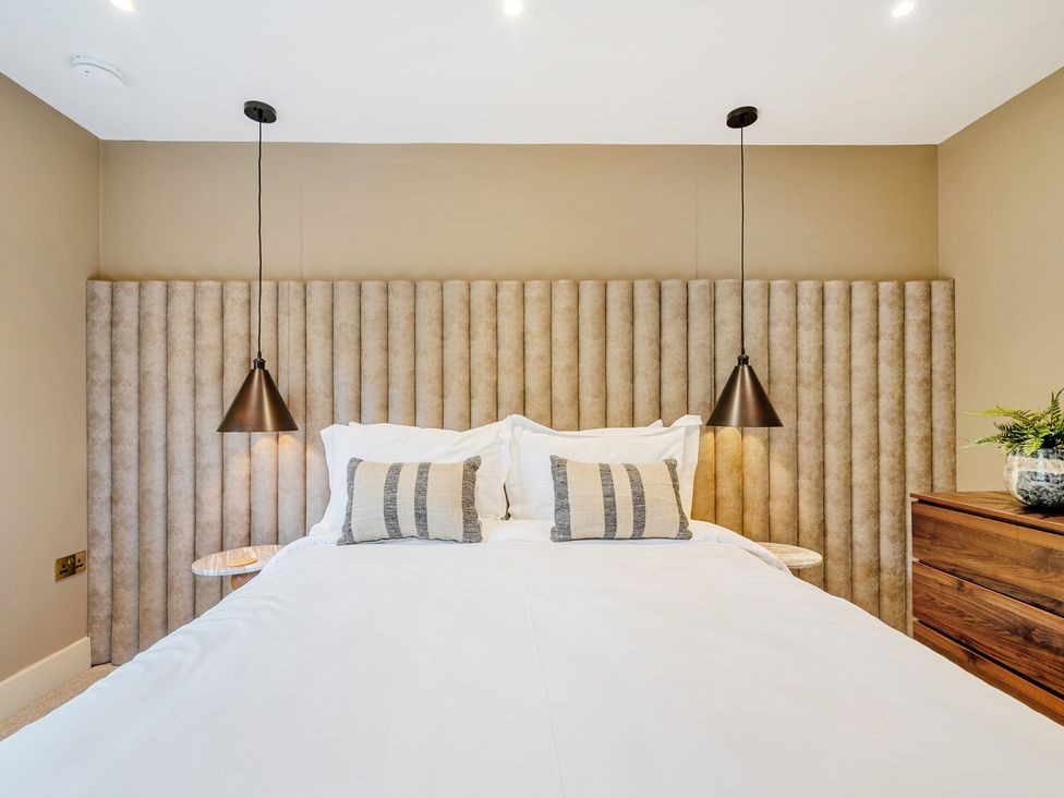 A bedroom with a bed and decorative headboard at Bell House in Llanfechell
