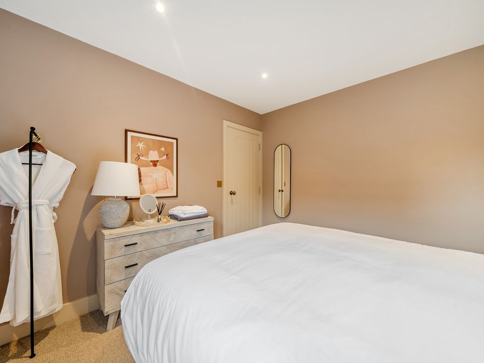 A bedroom with a bed and a lamp at Bell House in Llanfechell