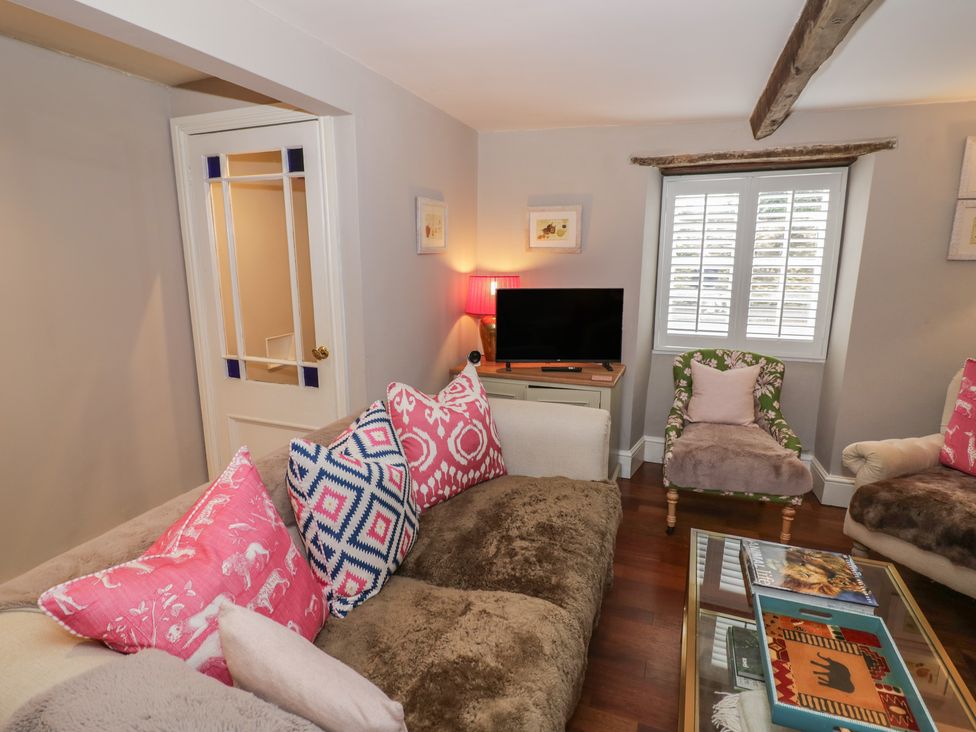 A living room with a sofa and television at 23 New Church Street Tetbury