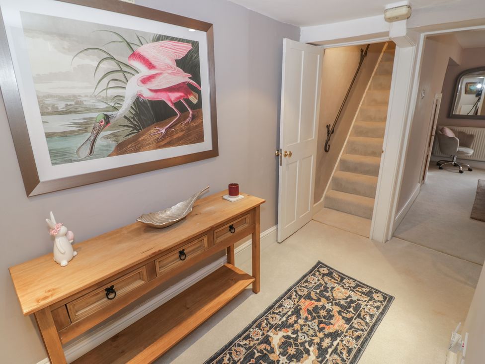 A hallway with a console table and a painting at 23 New Church Street, Tetbury