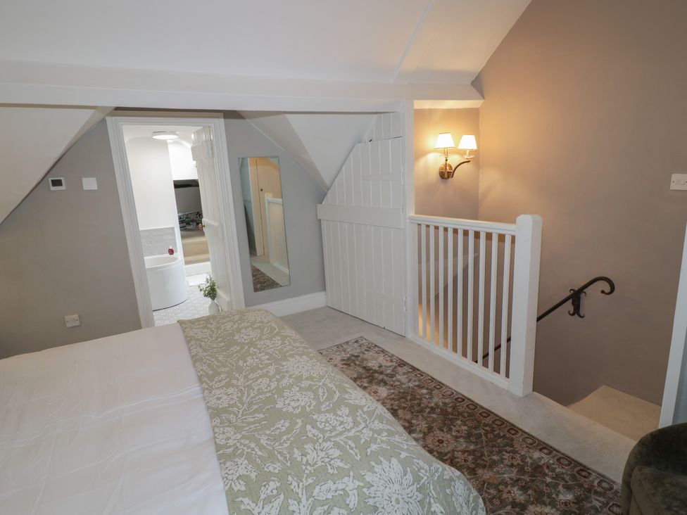 A bedroom with a staircase and a mirror view at 23 New Church Street Tetbury