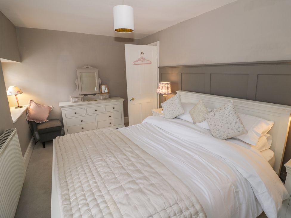 A bedroom with a bed and dresser at 23 New Church Street, Tetbury
