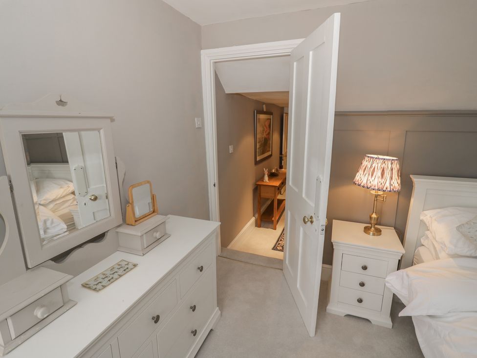 A bedroom with a bed, dresser, and mirror at 23 New Church Street Tetbury