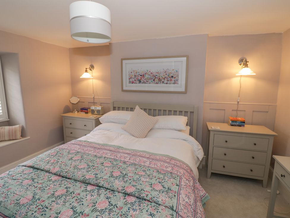 A bedroom with a bed and bedside table at 23 New Church Street in Tetbury