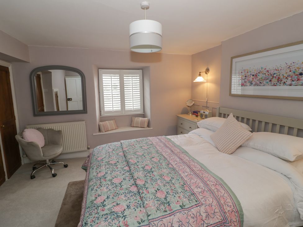 A bedroom with a bed and a chair at 23 New Church Street Tetbury