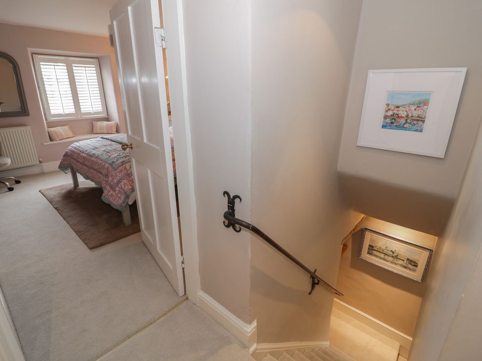 A staircase leading to a bedroom with a bed and a window at 23 New Church Street Tetbury