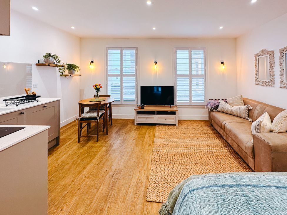 A living room with a sofa and television at Ammil Bespoke