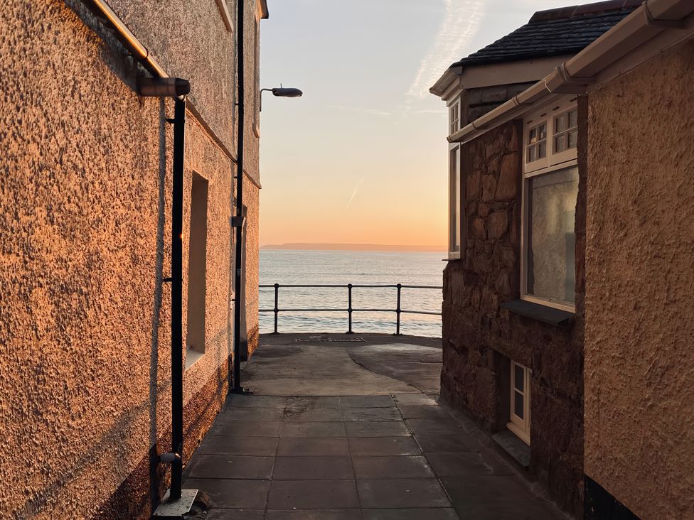 A walkway between buildings leading to the sea at Ammil Bespoke