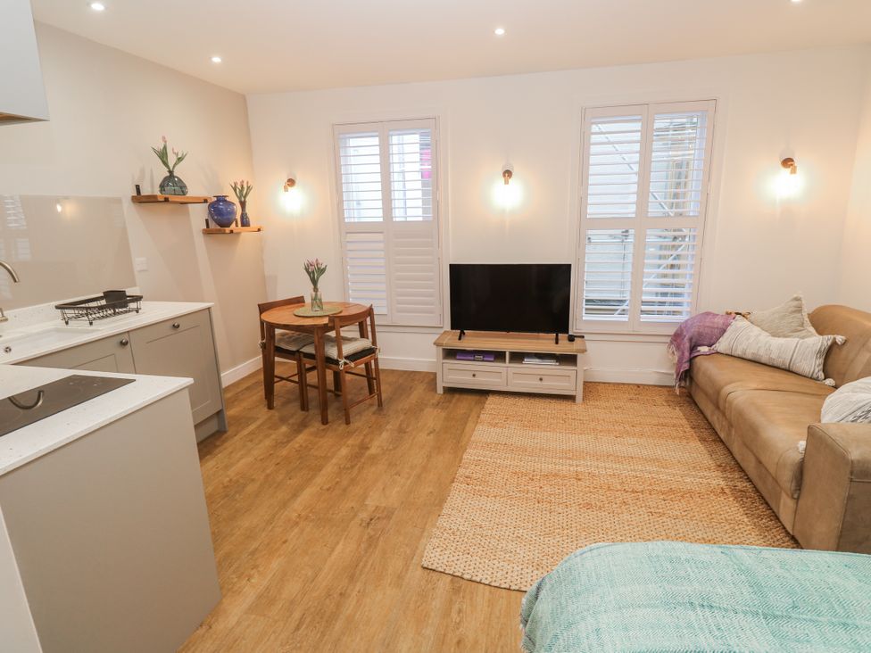 A living room with a sofa a table and a television at Ammil Bespoke in St Ives