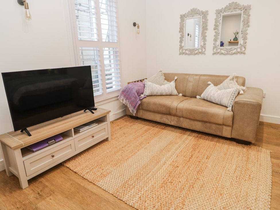 A living room with a sofa and television at Ammil Bespoke in St Ives
