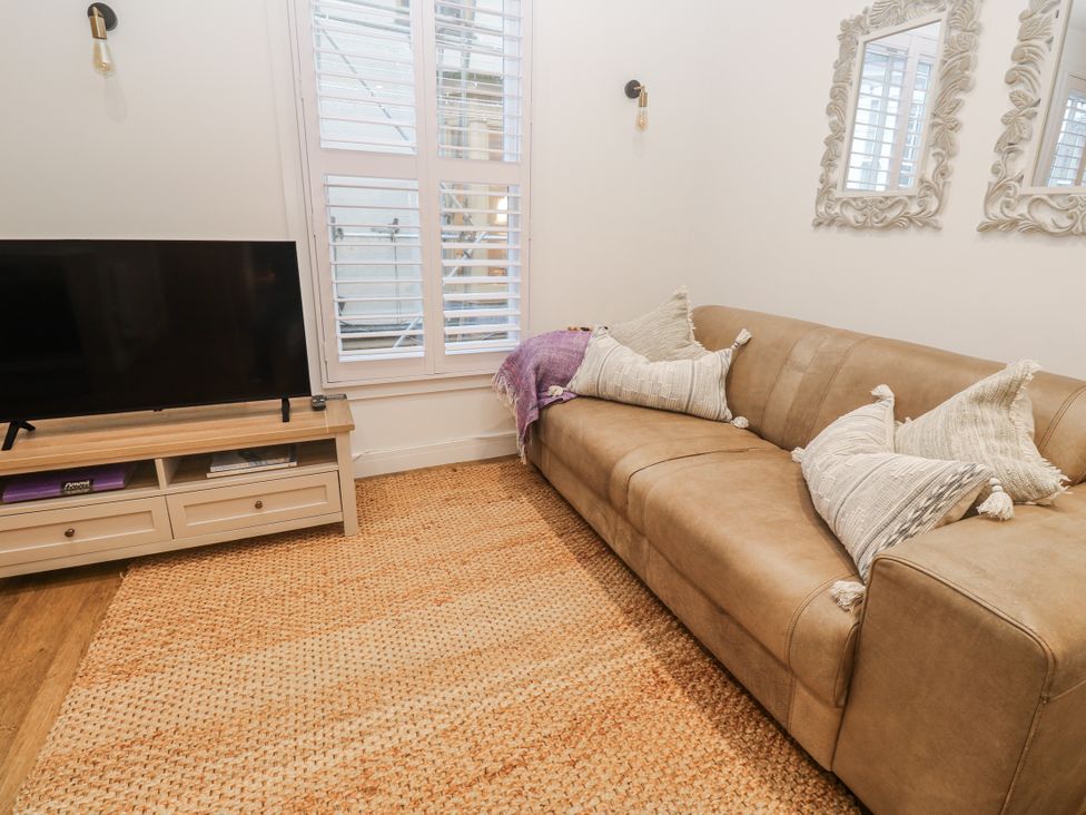 A living room with a television and sofa at Ammil Bespoke in St Ives