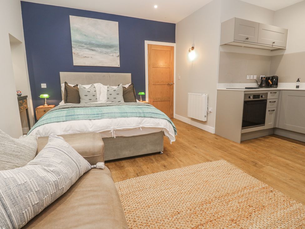A bedroom with a bed and kitchenette at Ammil Bespoke St Ives