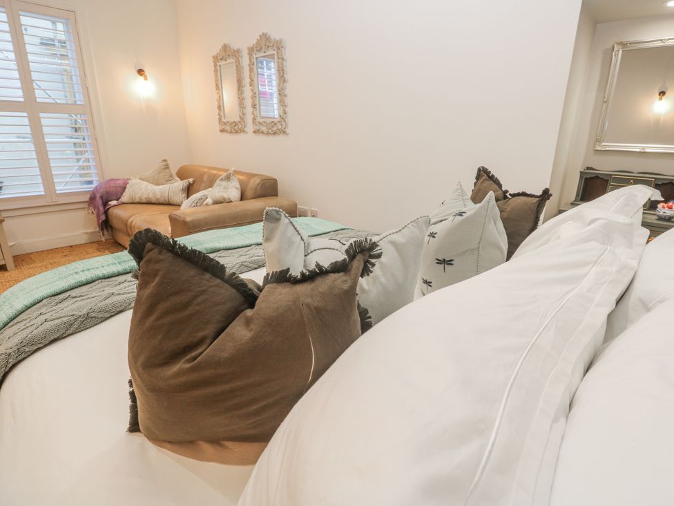 A bedroom with pillows and a sofa at Ammil Bespoke in St Ives