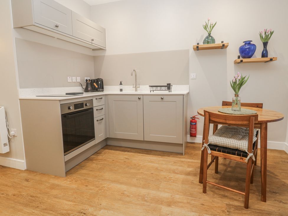 A kitchen with a dining table and flowers at Ammil Bespoke St Ives