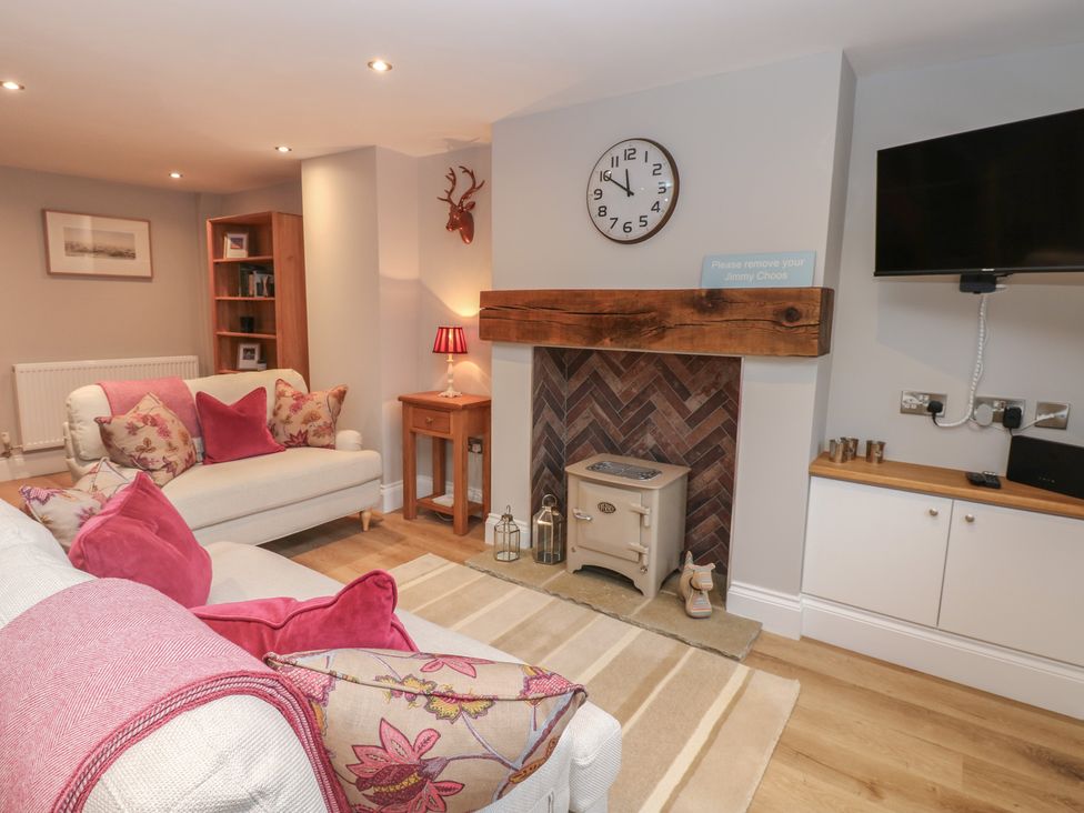 A living room with a fireplace and sofa at Brooklyn Cottage in Kirkby Malzeard
