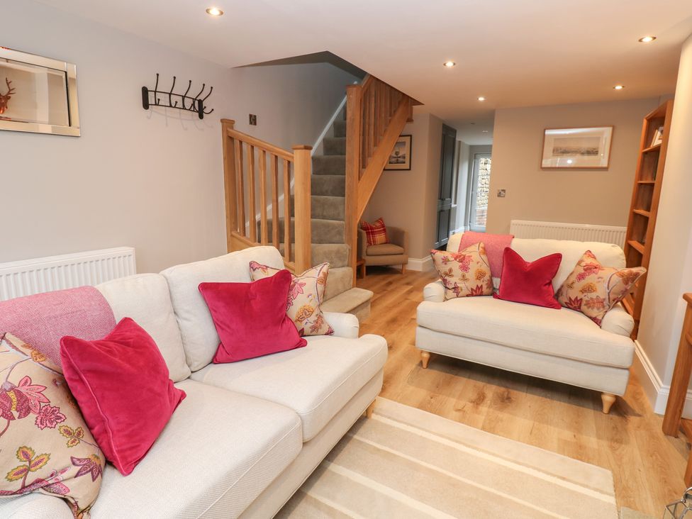 A living room with sofas and a staircase at Brooklyn Cottage in Kirkby Malzeard