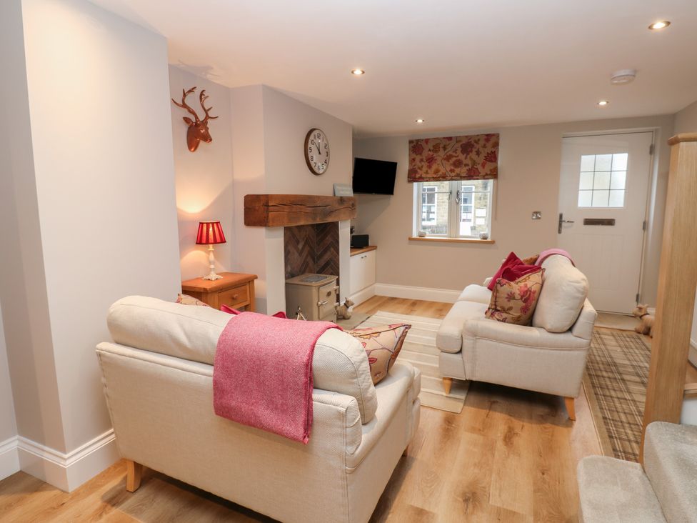 A living room with sofas and a fireplace at Brooklyn Cottage in Kirkby Malzeard