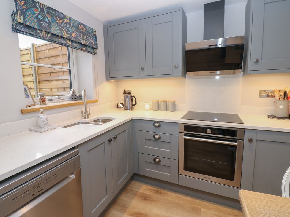 A kitchen with cabinets, sink, and oven at Brooklyn Cottage in Kirkby Malzeard