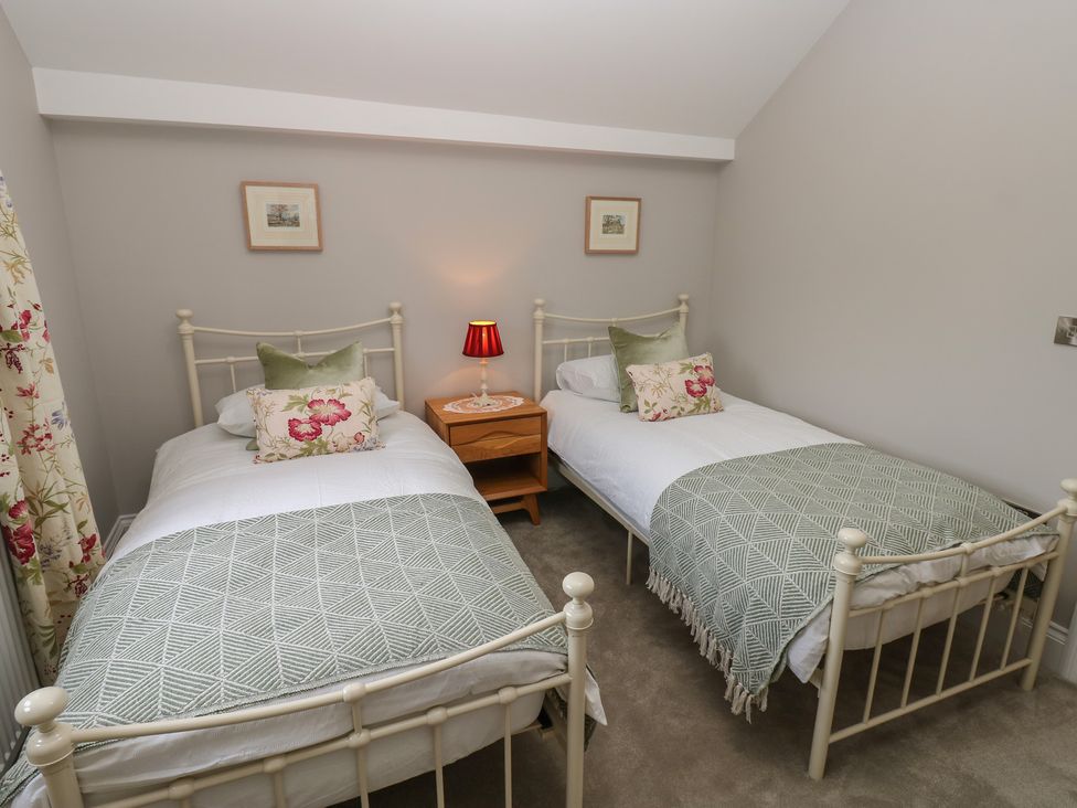 A bedroom with two single beds and a nightstand at Brooklyn Cottage in Kirkby Malzeard