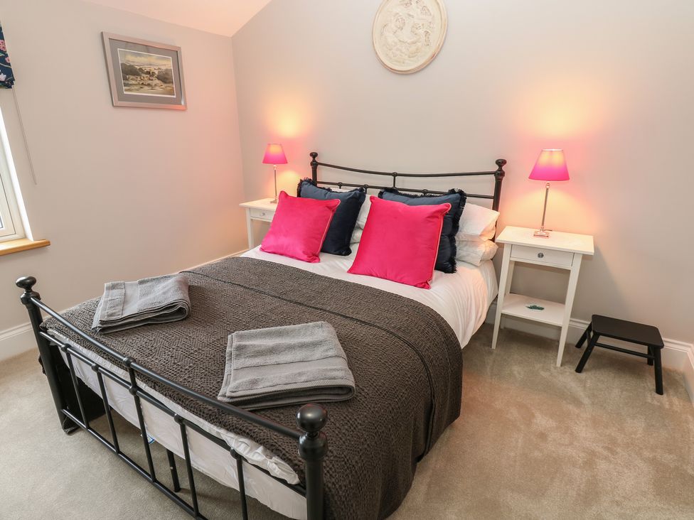 A bedroom with a bed and bedside tables at Brooklyn Cottage in Kirkby Malzeard