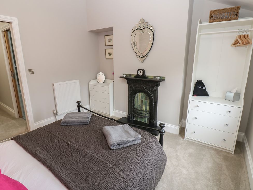 A bedroom with a bed and a fireplace at Brooklyn Cottage in Kirkby Malzeard