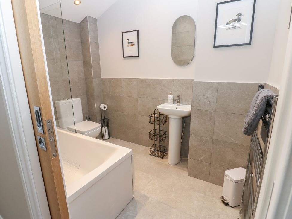A bathroom with a bathtub, sink, and toilet at Brooklyn Cottage in Kirkby Malzeard