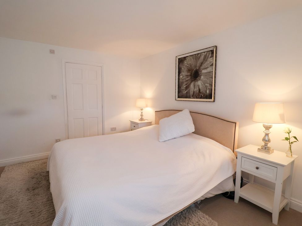 A bedroom with a bed and nightstands at Three Ways in South Lopham near Garboldisham