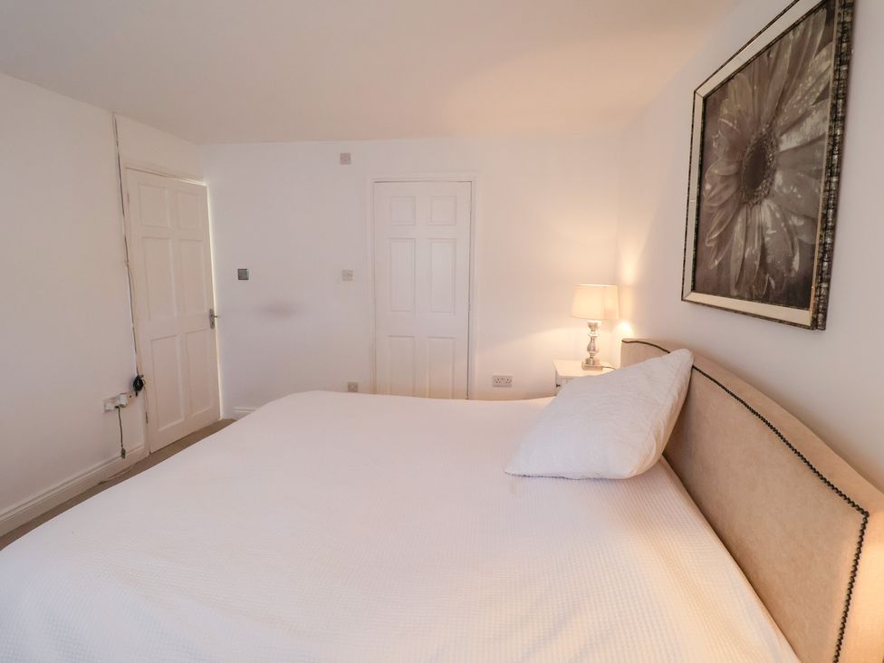 A bedroom with a bed and lamp at Three Ways South Lopham near Garboldisham