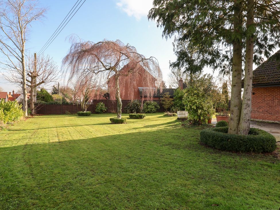 A garden with trees and grass at Three Ways South Lopham near Garboldisham