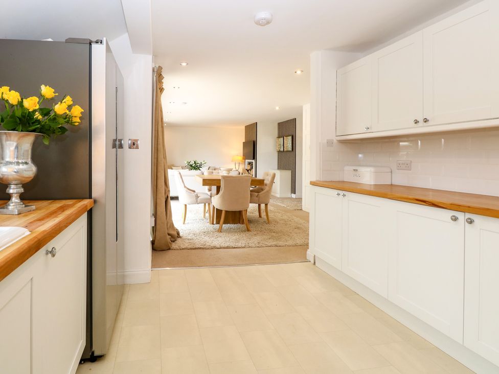 A kitchen with cabinets and a refrigerator at Three Ways South Lopham near Garboldisham