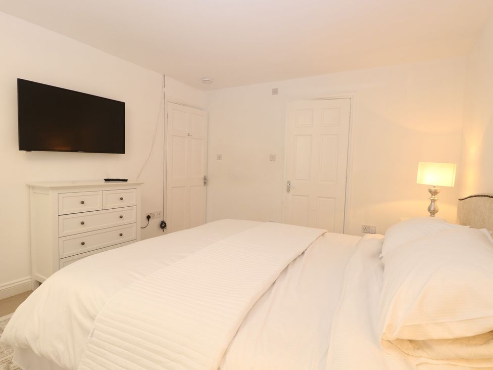 A bedroom with a bed and dresser at Three Ways in South Lopham near Garboldisham
