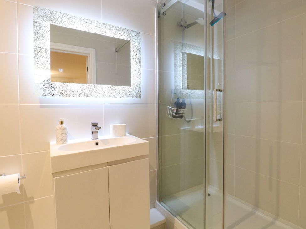 A bathroom with a sink, mirror, and shower at Three Ways in South Lopham near Garboldisham