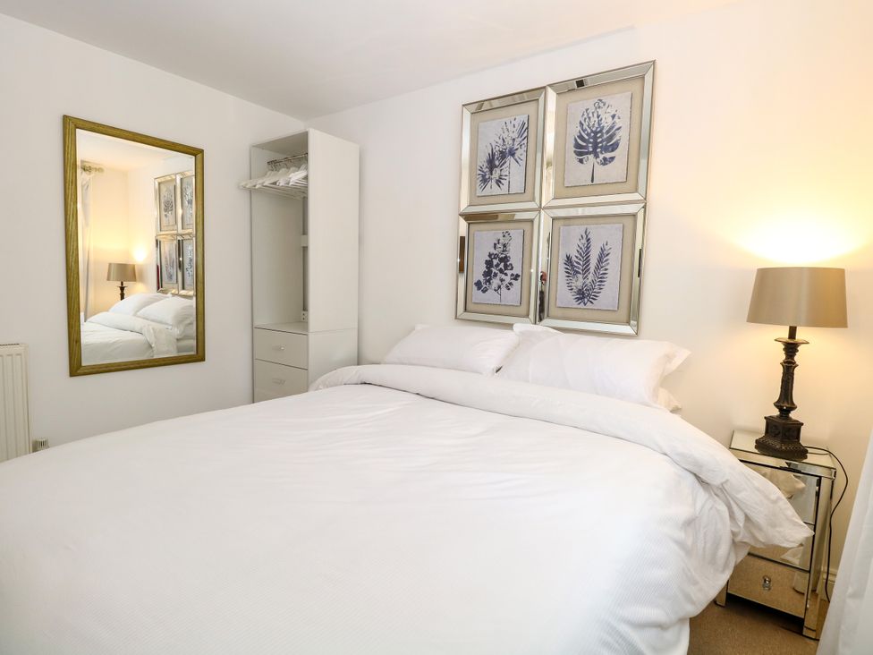 A bedroom with a bed and framed pictures at Three Ways in South Lopham near Garboldisham