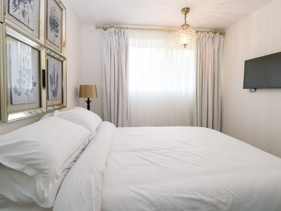 A bedroom with a bed and wall art at Three Ways in South Lopham near Garboldisham