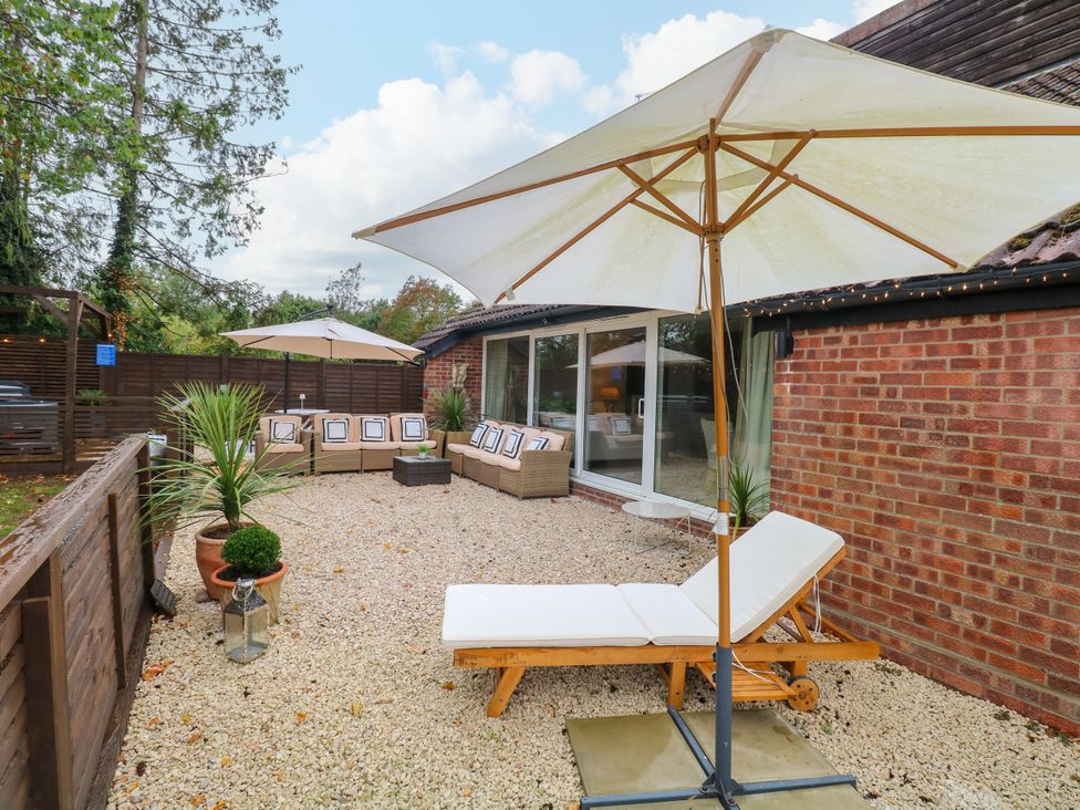 A garden area with furniture and umbrellas at Three Ways South Lopham near Garboldisham