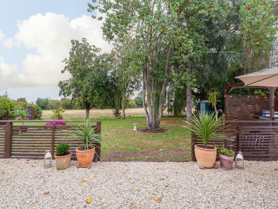 A garden with trees and planters at Three Ways in South Lopham near Garboldisham