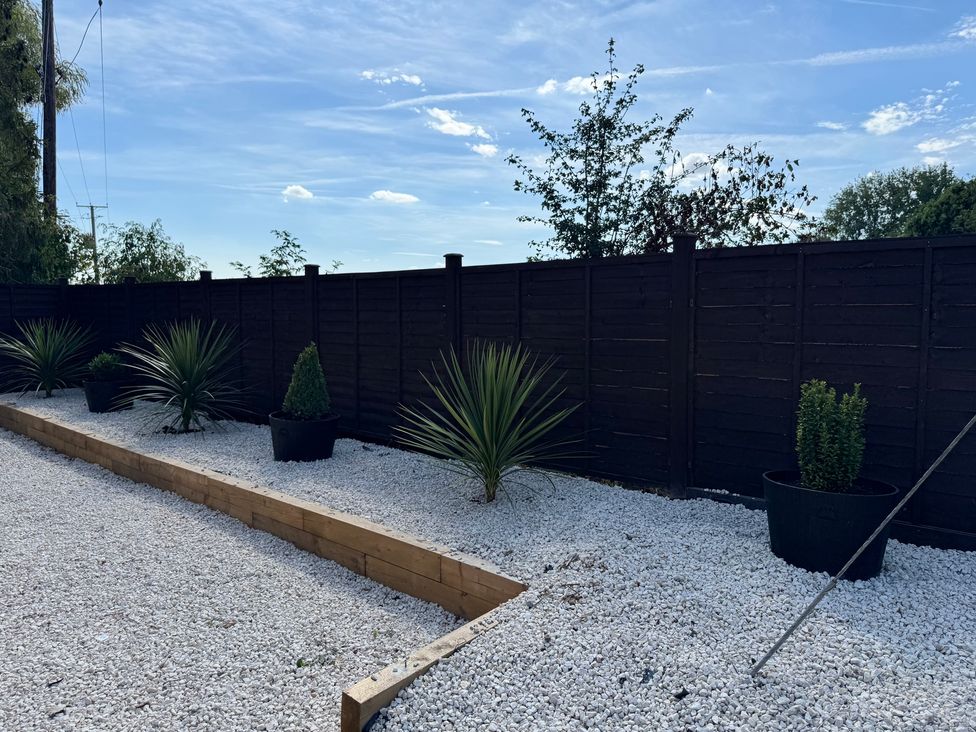 A garden with gravel and planters at Three Ways in South Lopham near Garboldisham