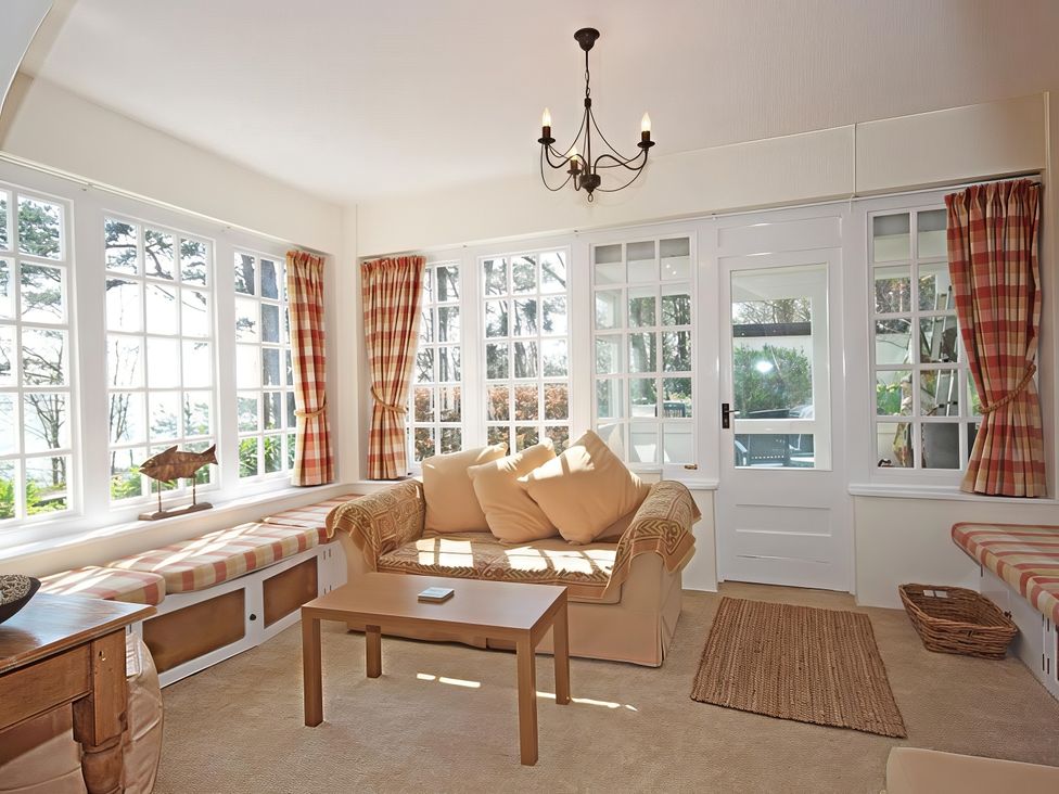 A conservatory with a sofa and coffee table at 4 Ringrone, Salcombe