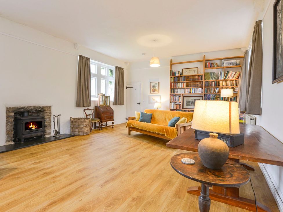 A living room with a sofa and bookshelf at School House in Ivybridge