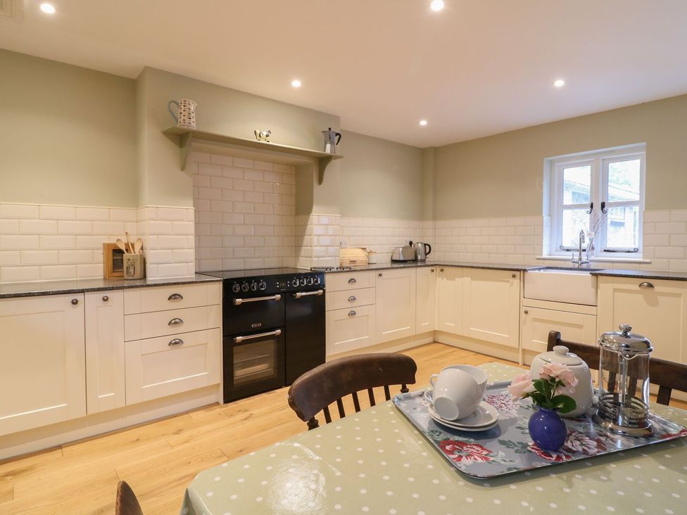 A kitchen with cabinets and appliances at School House in Ivybridge